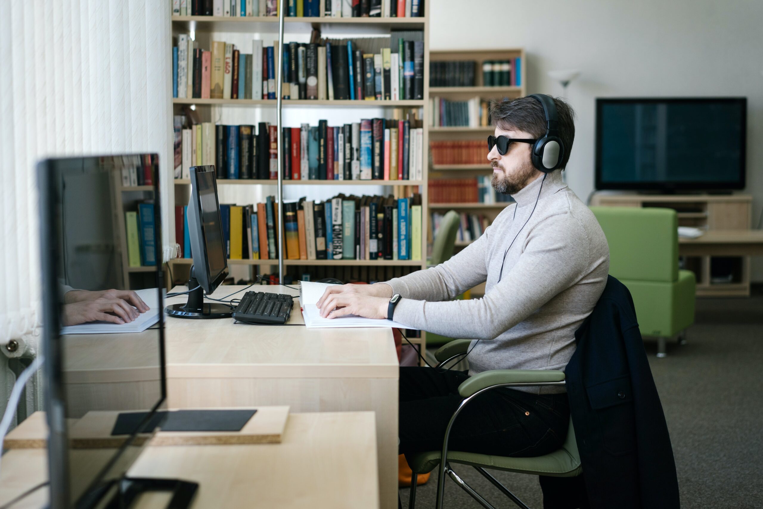     Visually impaired man sitting at a desk